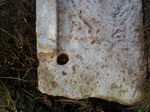 Because of the holes I presume that this is the bottom side of the step of a sort that was maybe stuck onto small round stone stakes, preventing a step to slide. 

Of course this is only my speculation.